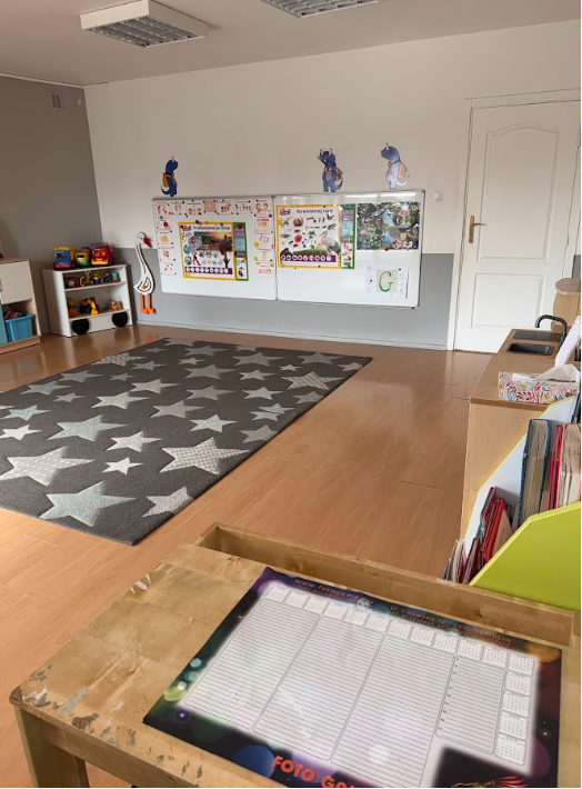 Sala z dywanem w gwiazdki i tablicami edukacyjnymi