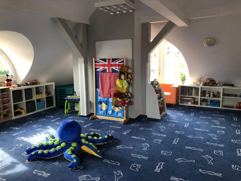 Sala zabaw z kącikiem teatralnym i miękkim dywanem